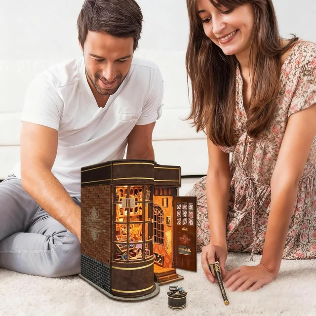 CUTEROOM Two people assembling the miniature magic shop
